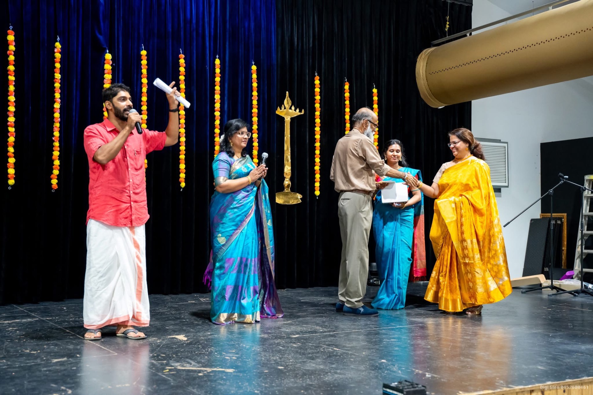 MC presenting an award on stage at a community function