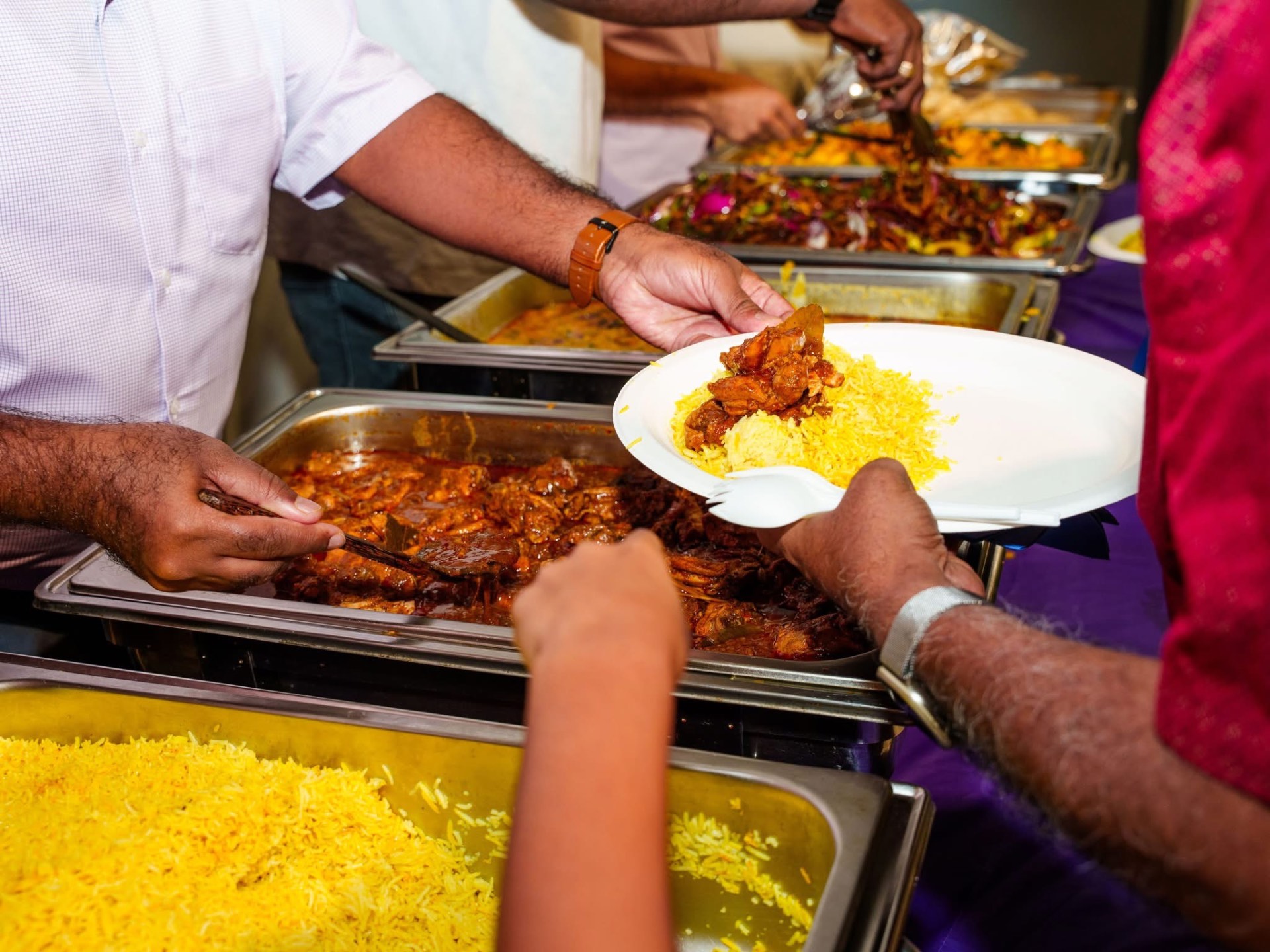 Serving biryani and curries at a community dinner
