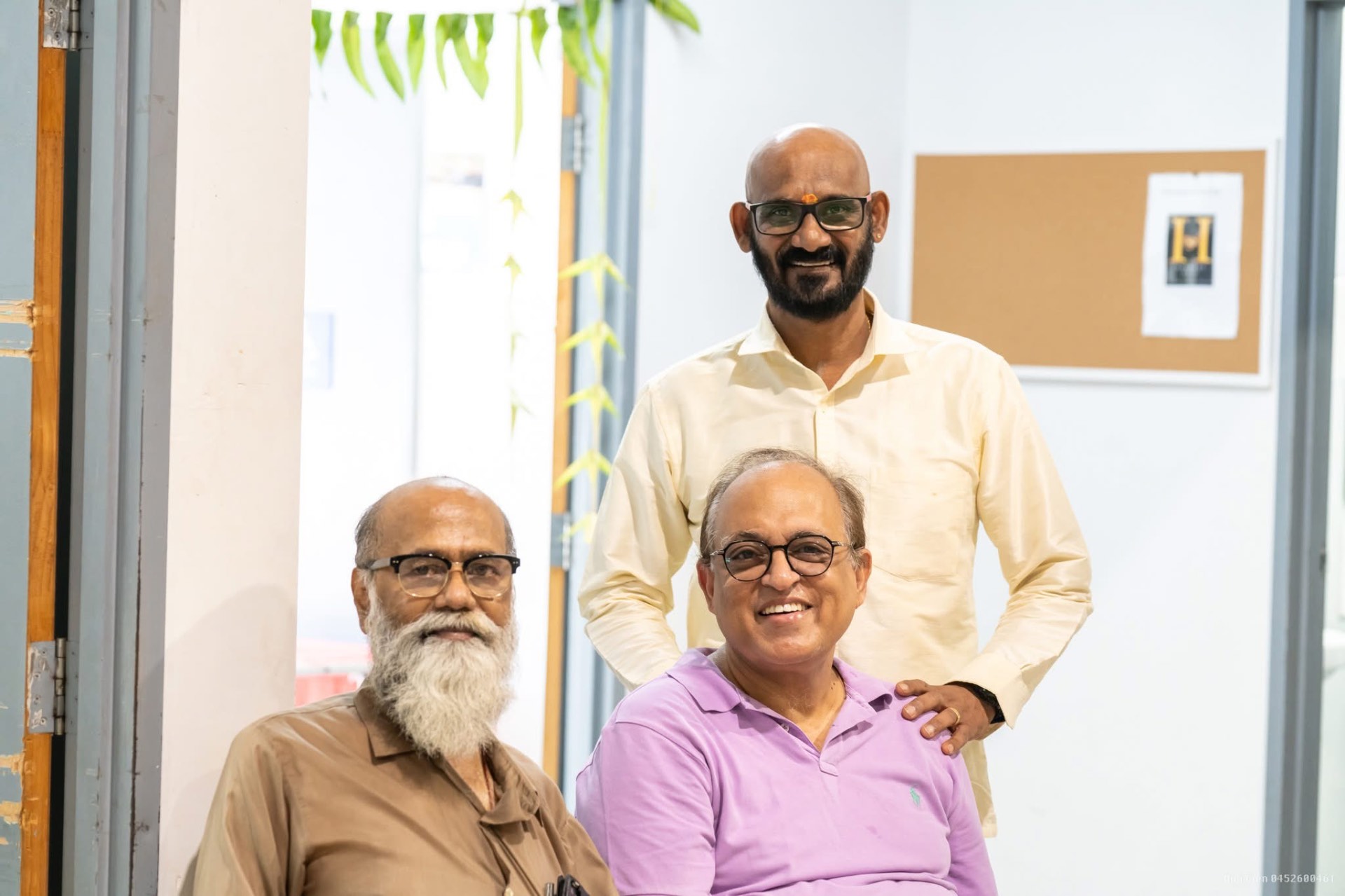 Three community elders smiling for a portrait